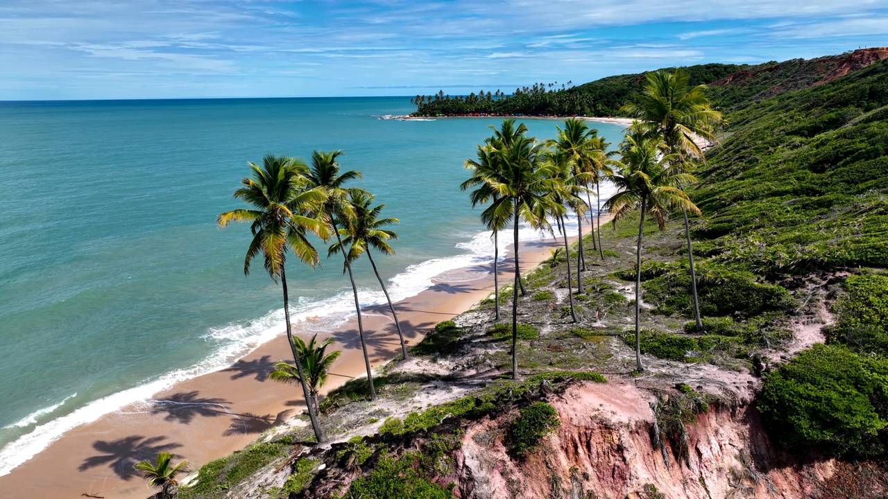 Falésias, mar azul e coqueiros criam uma paisagem que dá vontade de ficar