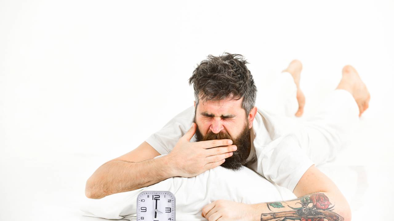 Pessoa deitada na cama &agrave; noite com express&atilde;o de cansa&ccedil;o ap&oacute;s acordar repetidamente de madrugada