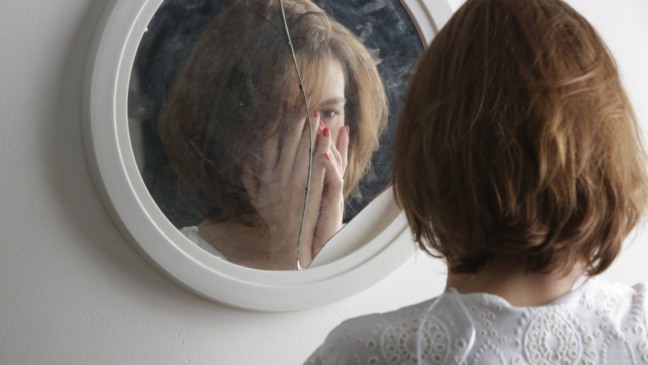 Pessoa sozinha refletindo, representando o impacto da autoestima instável nas relações pessoais e no trabalho.