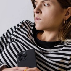 Pessoa com expressão de cansaço sentada em ambiente interno, representando bem-estar em baixa