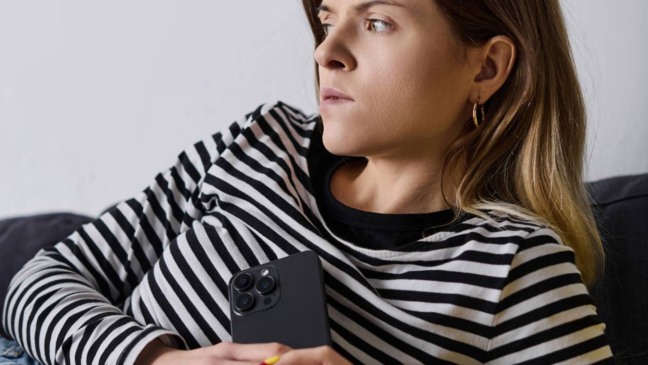 Pessoa com expressão de cansaço sentada em ambiente interno, representando bem-estar em baixa