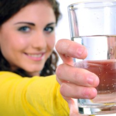 Copo de &aacute;gua sendo bebido ao longo do dia para ajudar a reduzir a reten&ccedil;&atilde;o de l&iacute;quidos