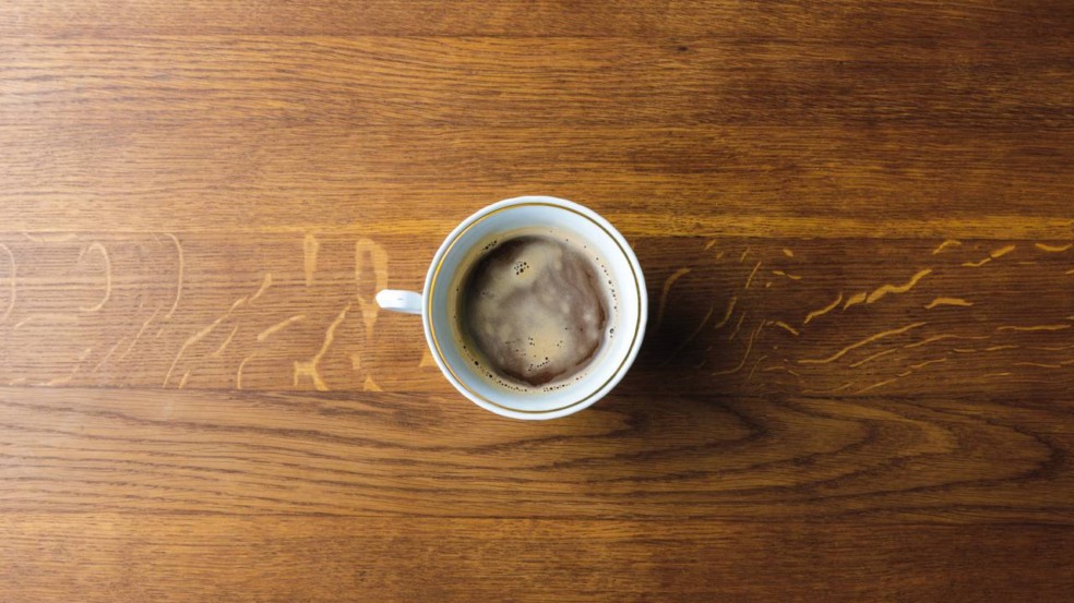 Xícara de café sobre a mesa representando o consumo diário e o café em excesso Xícara de café sobre a mesa representando o consumo diário e o café em excesso