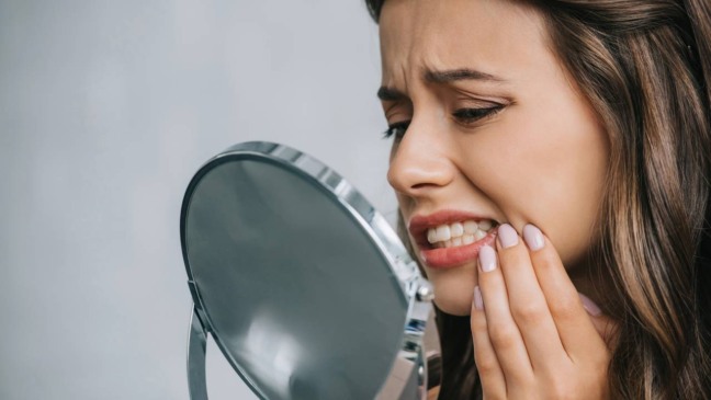Pessoa refletindo sobre sonho com dentes quebrando, ligado a estresse e preocupações com a saúde bucal