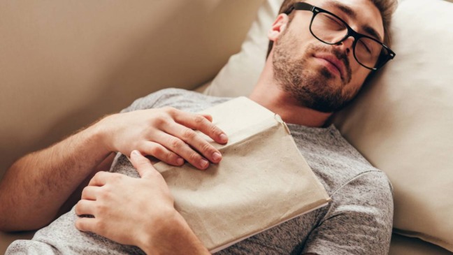 Pessoa sentada em silêncio, com expressão de cansaço, em um ambiente calmo, representando a diferença entre dormir e ter descanso físico, mental e emocional de verdade.