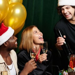 Uma família reunida ao redor da mesa brinca com biscoitos, copos e doces de Natal, rindo enquanto participa de desafios simples e acessíveis que usam materiais comun