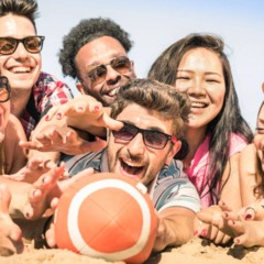 Pessoas jogando jogos de praia na areia para se manter ativas de forma leve e divertida
