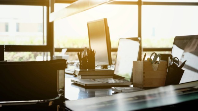Ambiente iluminado pela luz natural, com mesa de trabalho próxima à janela, promovendo foco, bem-estar e produtividade