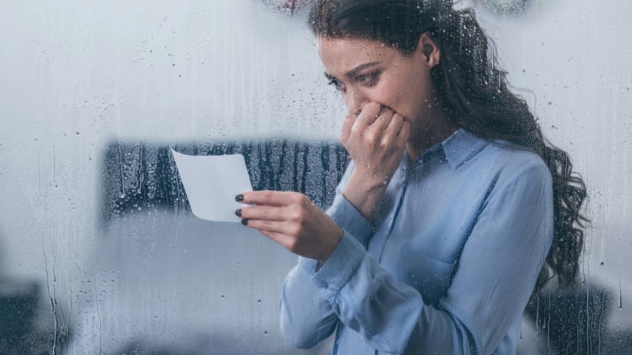Pessoa olhando para uma foto antiga, simbolizando lembran&ccedil;as, idealiza&ccedil;&atilde;o do passado e ref&uacute;gio emocional