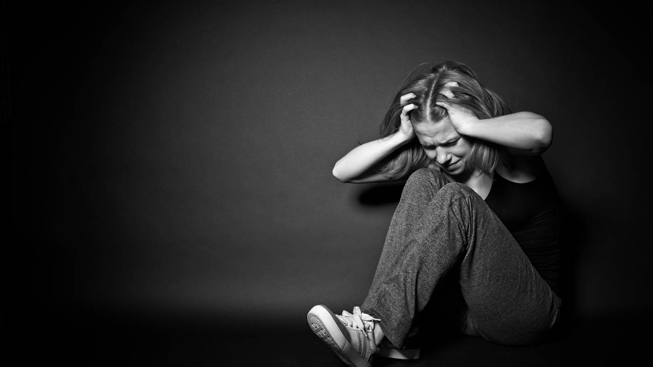 M&atilde;os cobrindo o rosto enquanto a pessoa chora, ilustrando vulnerabilidade