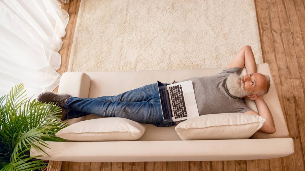 Pessoa deitada no sofá tentando descansar enquanto demonstra expressão de culpa e inquietação Pessoa deitada no sofá tentando descansar enquanto demonstra expressão de culpa e inquietação