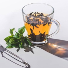 Xícara de chá quente preparada com ervas naturais para promover sensação de bem-estar