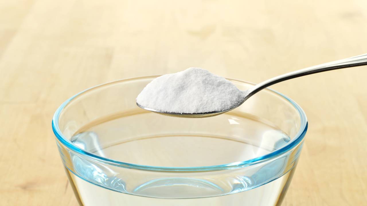 Bicarbonato de sódio sendo usado no ralo da pia da cozinha para combater mau cheiro.