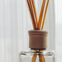 Difusor aromático com varetas em sala, mostrando como a essência caseira perfuma o ambiente de forma contínua.