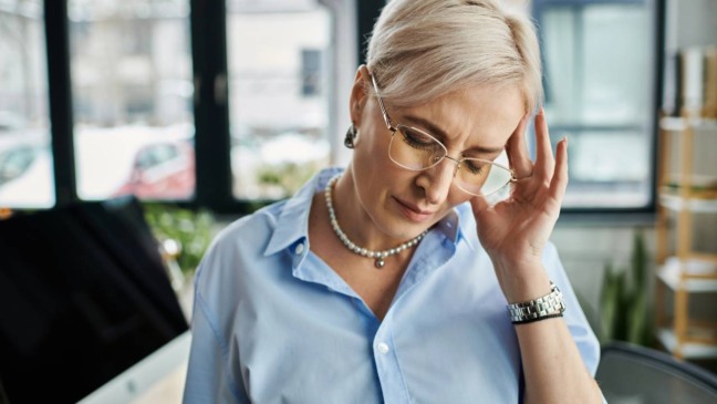 Pessoa com expressão de cansaço emocional refletindo sobre sinais do próprio corpo