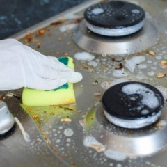 Fog&atilde;o com gordura acumulada e respingos de comida antes da limpeza na cozinha.