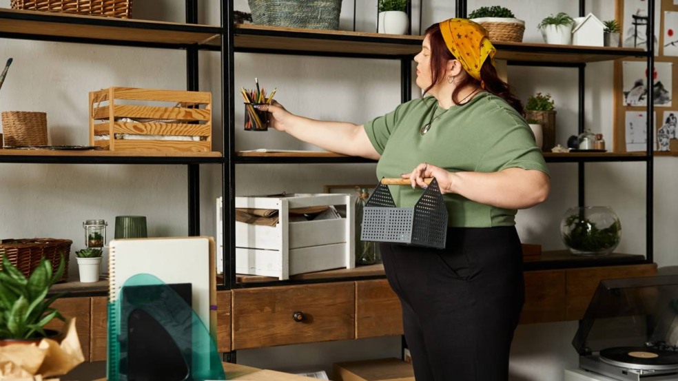 Mulher organizando prateleiras e objetos em um ambiente compacto. Mulher organizando prateleiras e objetos em um ambiente compacto.