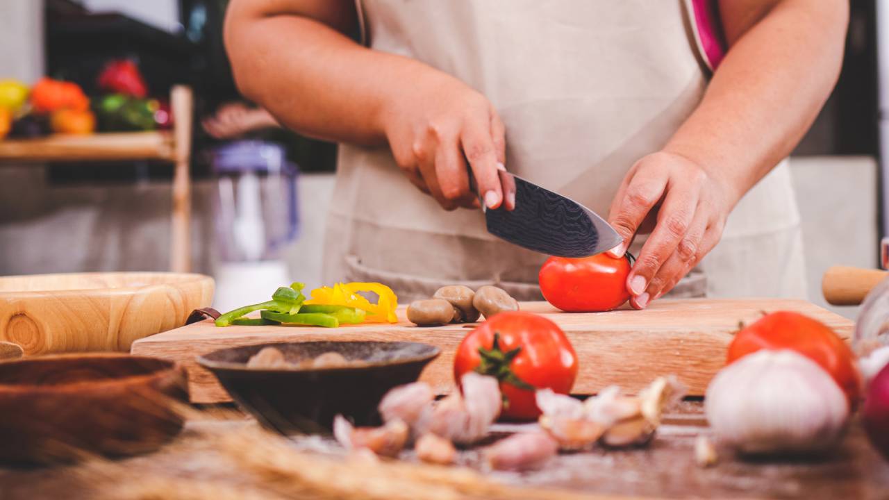 Pessoa cozinhando refeição barata em cozinha doméstica.