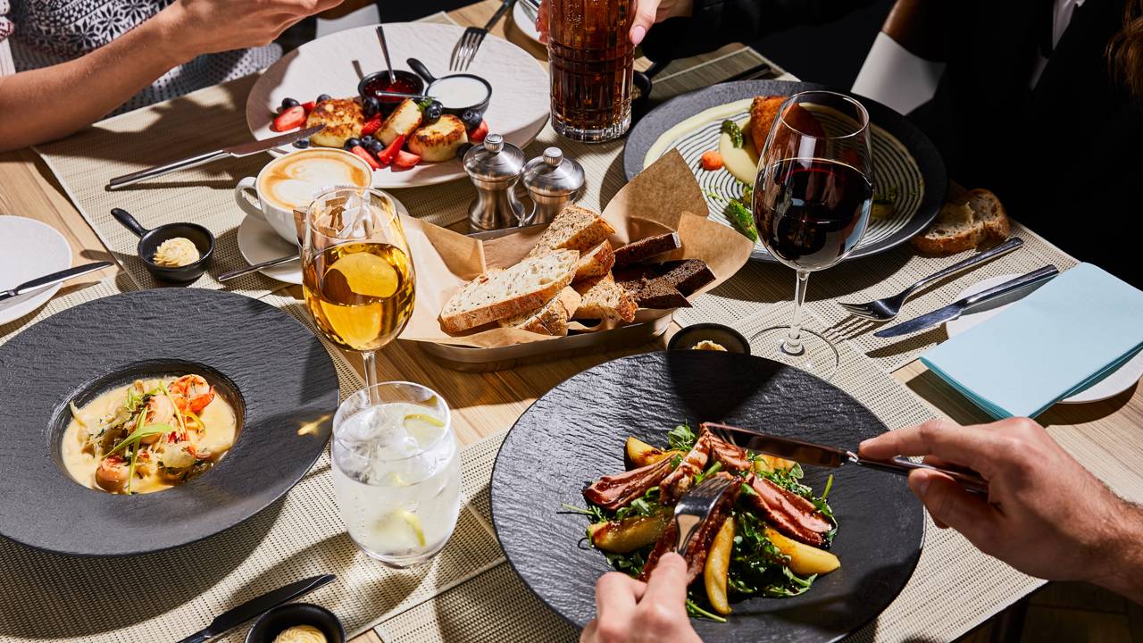 Interior de espa&ccedil;o gastron&ocirc;mico em Niter&oacute;i com mesas e decora&ccedil;&atilde;o contempor&acirc;nea.