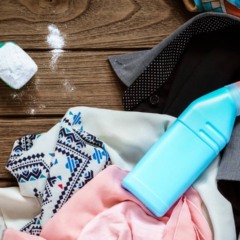 Pessoa mexendo água, amaciante concentrado e álcool em recipiente limpo para fazer spray caseiro de roupas.