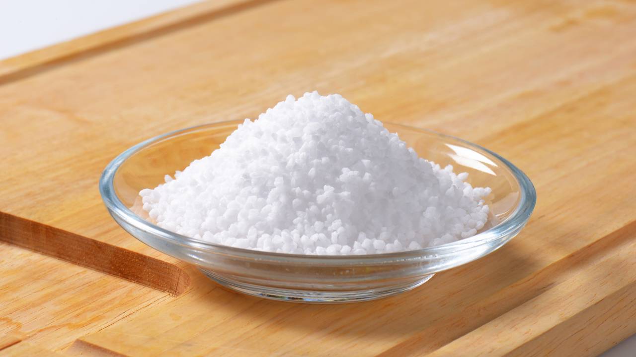 Recipiente simples com sal grosso posicionado pr&oacute;ximo &agrave; entrada da casa.